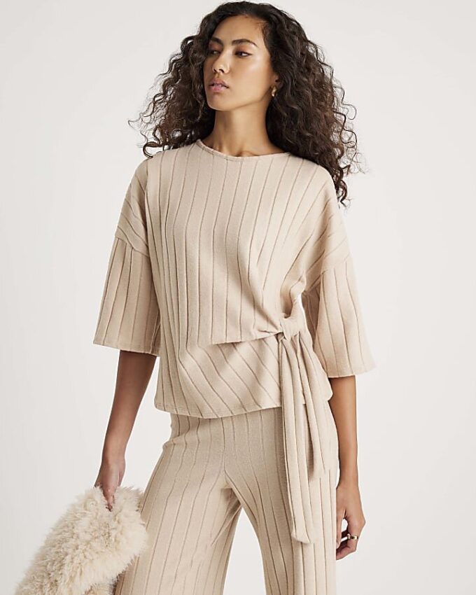 Beige kortärmad topp med breda ribbade sidoknutar