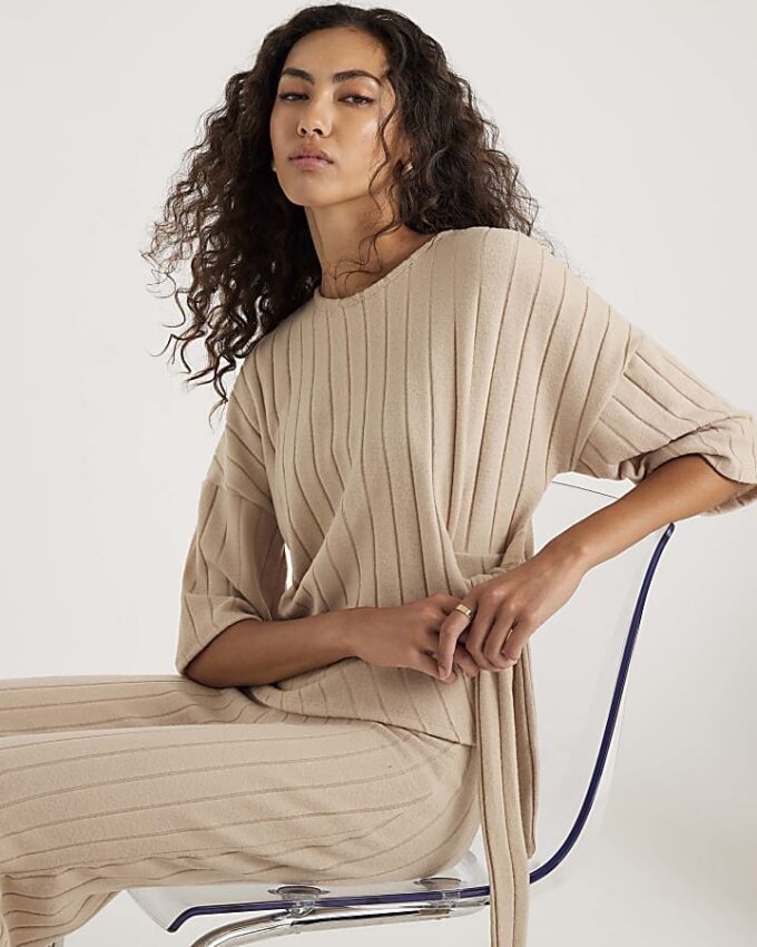 Beige kortärmad topp med breda ribbade sidoknutar