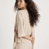 Beige kortärmad topp med breda ribbade sidoknutar