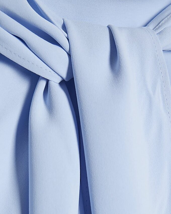 Blå blus med fladdermusärmar och rosett