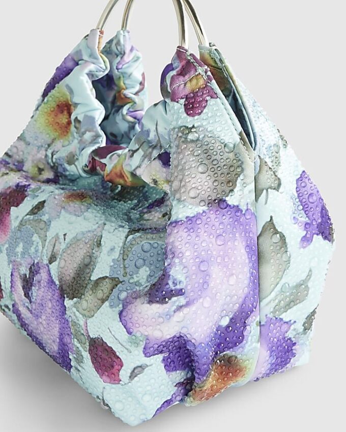 Blå clutchväska med blommiga dekorationer