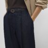 Blå jeans med bälte och splittad fåll