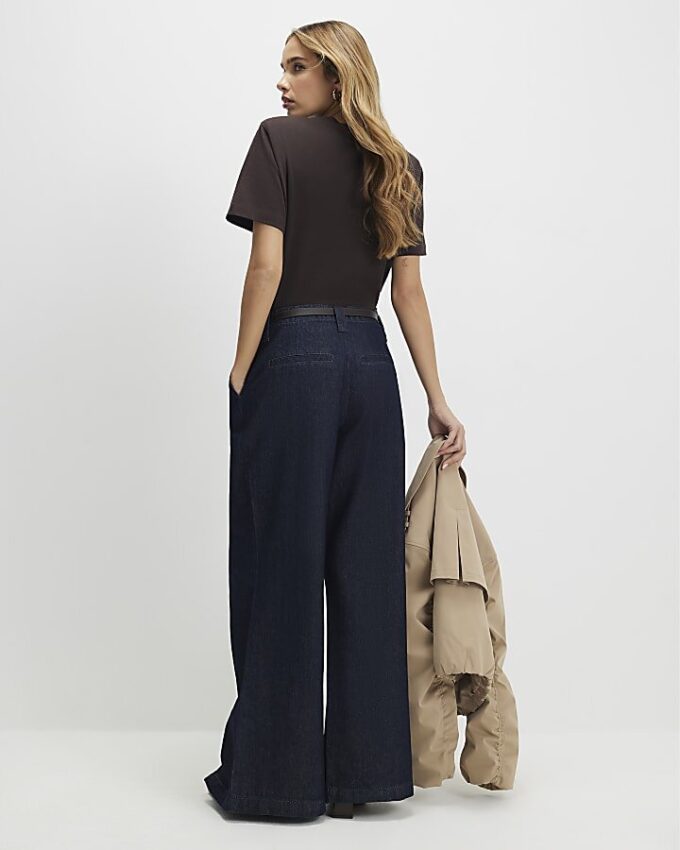 Blå jeans med bälte och splittad fåll