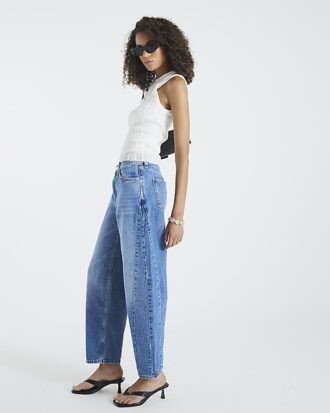 Blå jeans med sömmar och barellben
