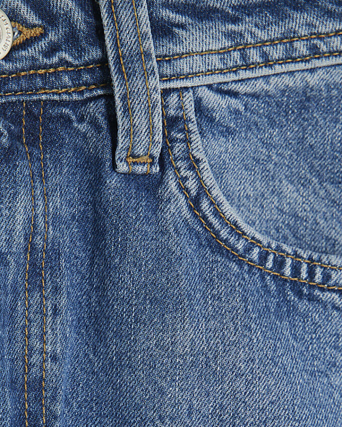 Blå jeans med sömmar och barellben