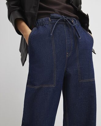 Blå jeans med snörning i midjan och barellben