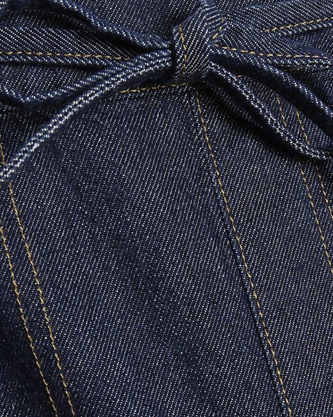 Blå jeans med snörning i midjan och barellben