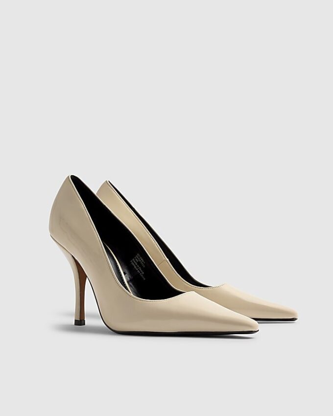 Creamfärgade pumps med lång spetsig tå och lackad yta