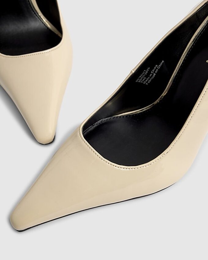 Creamfärgade pumps med lång spetsig tå och lackad yta