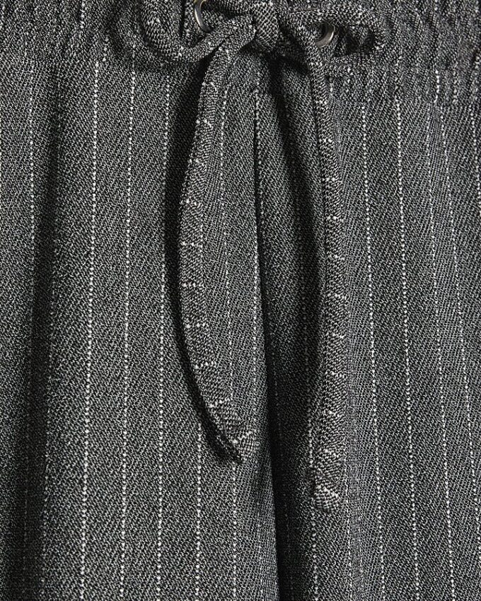 Gråa byxor med dragsko och breda ben i randigt tyg