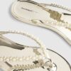 Guldfärgade flip-flops med pärldetaljer