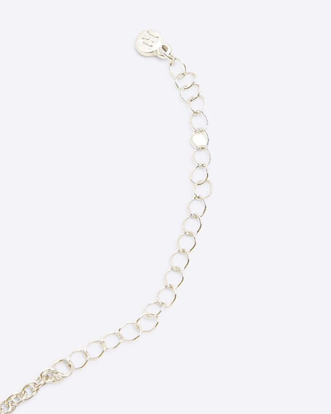 Halsband med silverfärgat korshänge