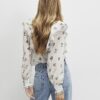 Krämfärgad blus med blommiga volanger