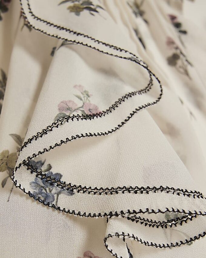Krämfärgad blus med blommiga volanger
