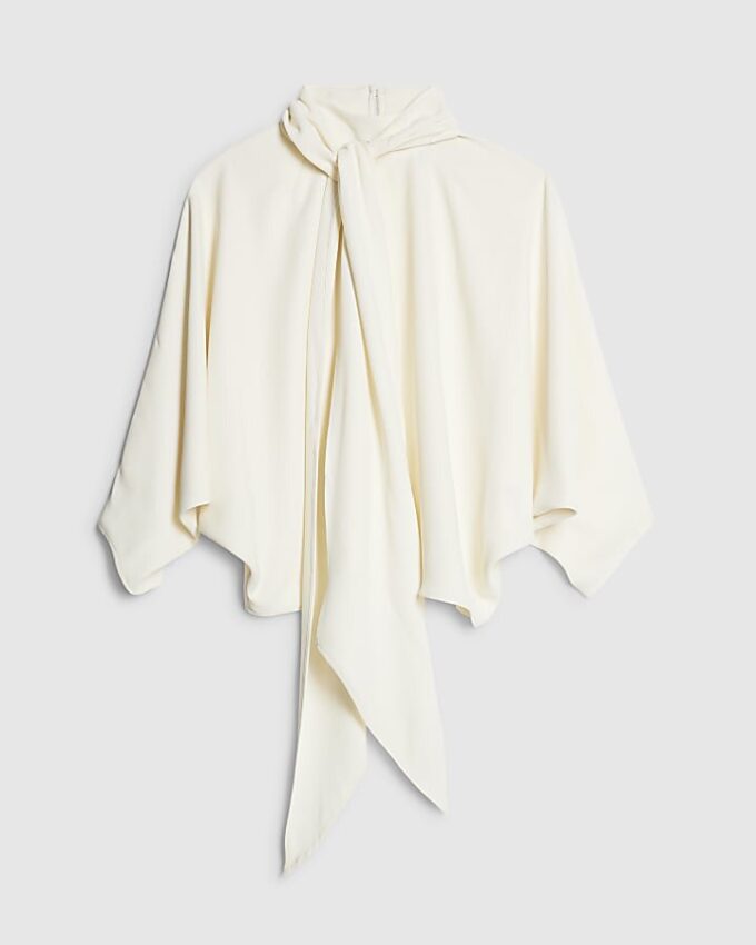 Krämfärgad blus med fladdermusärmar och rosett