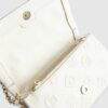 Krämfärgad crossbody-väska med präglat monogram
