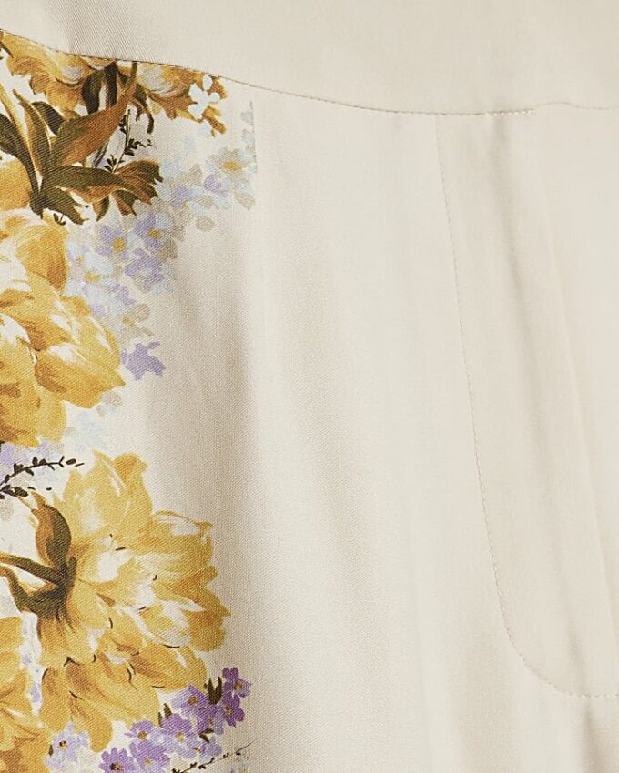 Krämfärgade blommiga byxor med vid ben