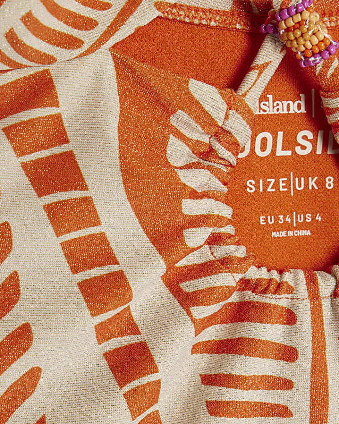 Orange baddräkt med metalliskt palmtryck