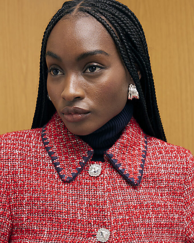 Röd boucléjacka med whipstitch