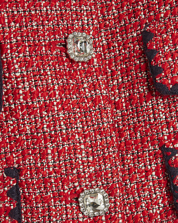 Röd boucléjacka med whipstitch