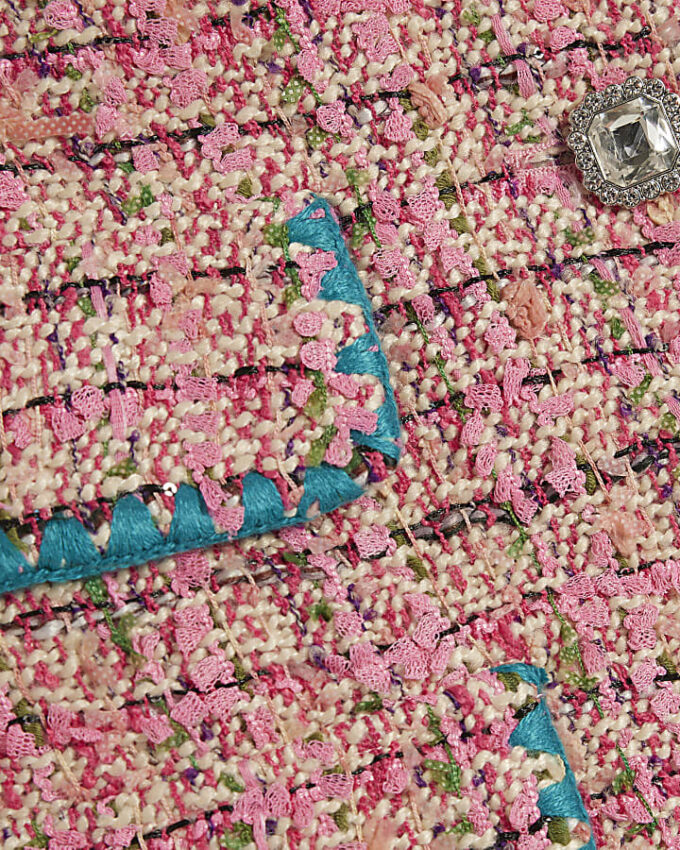 Rosa boucléjacka med whipstitch-sömmar