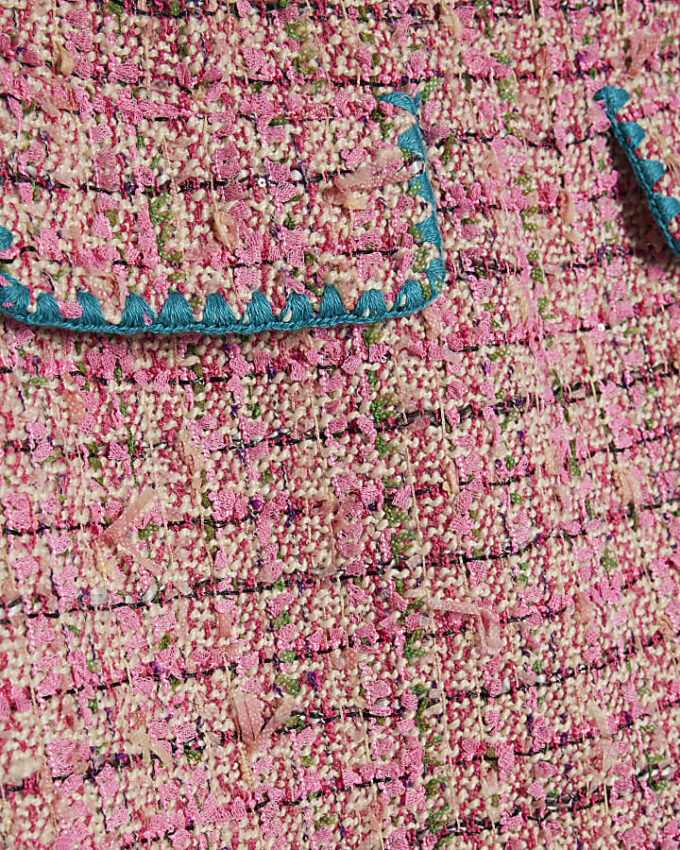 Rosa minikjol i bouclé med whipstitch