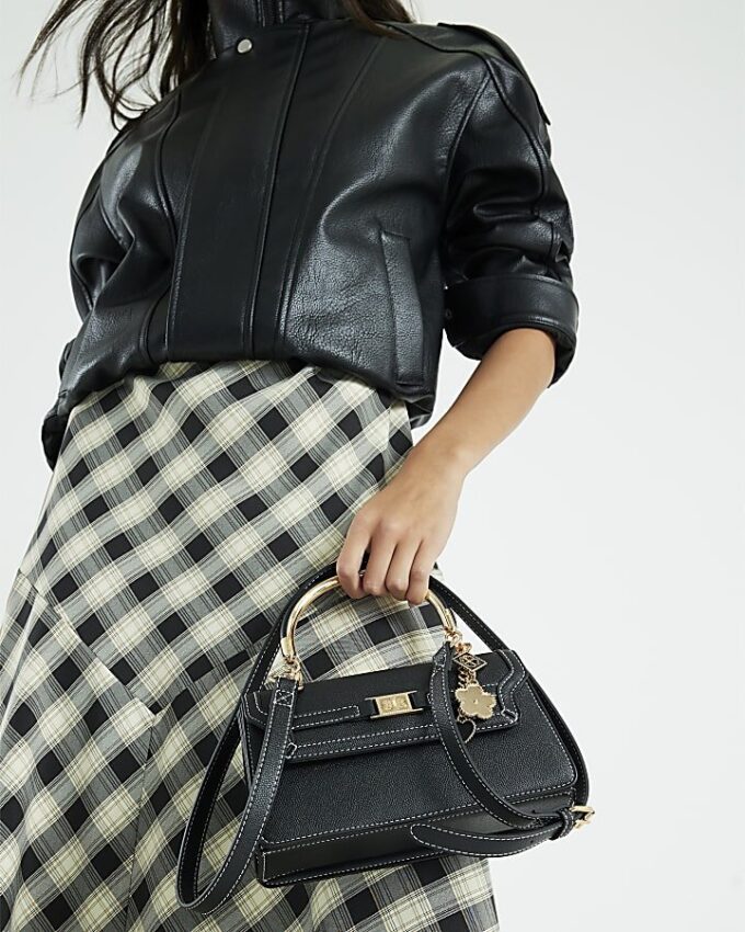 Svart liten totebag med metallhandtag och berlock