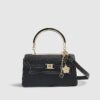 Svart liten totebag med metallhandtag och berlock