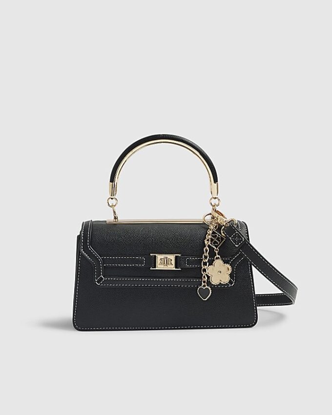 Svart liten totebag med metallhandtag och berlock