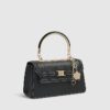 Svart liten totebag med metallhandtag och berlock