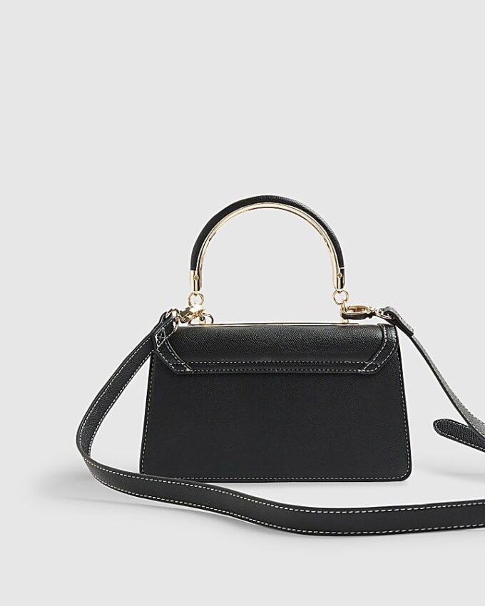 Svart liten totebag med metallhandtag och berlock