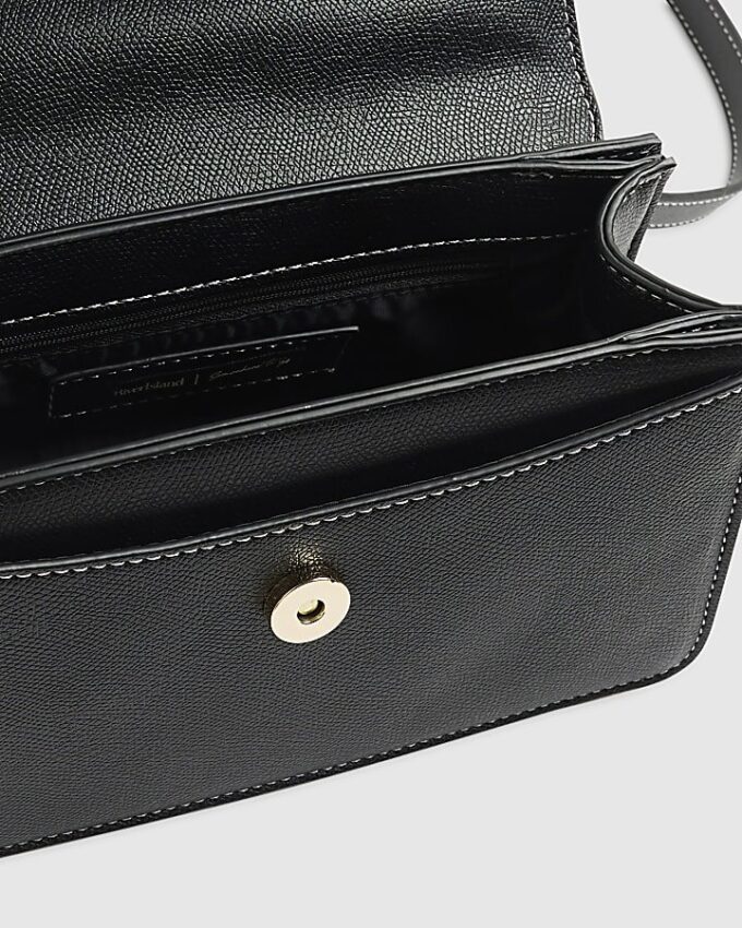 Svart liten totebag med metallhandtag och berlock