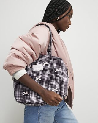 Svart resväska med gingham-mönster och rosett