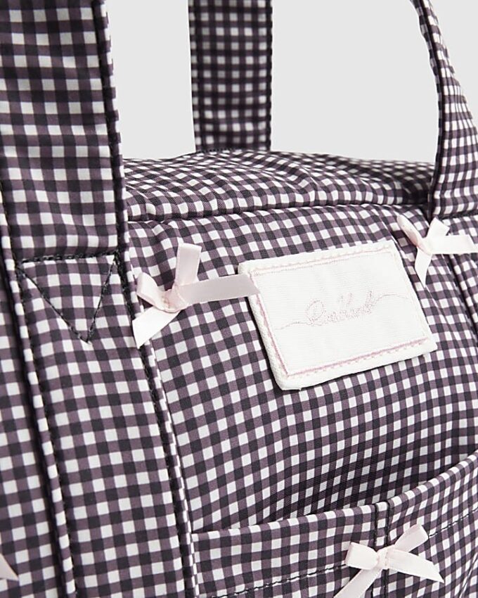 Svart resväska med gingham-mönster och rosett