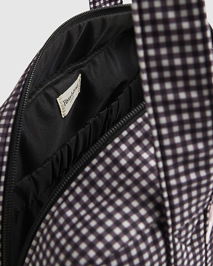 Svart resväska med gingham-mönster och rosett