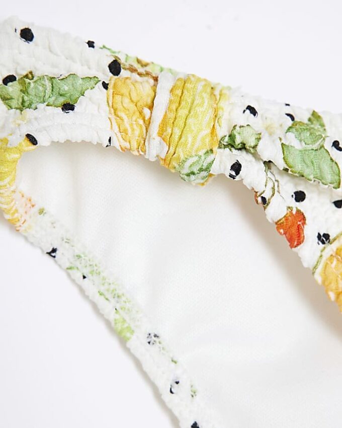 Vit texturerad bikinitrosa med fruktmönster